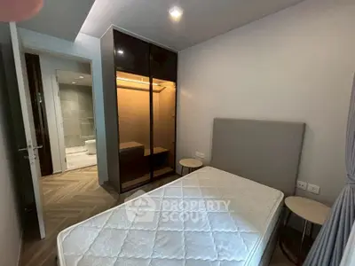 Modern bedroom with stylish wardrobe and ensuite bathroom in a contemporary apartment.