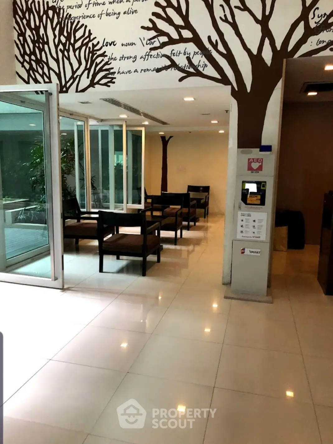 Modern lobby area with artistic tree wall design and seating, ideal for relaxation.