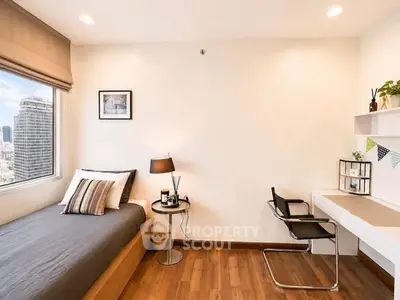 Modern bedroom with city view, sleek furnishings, and natural light.