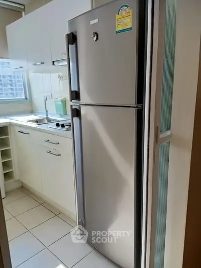 Modern kitchen with stainless steel fridge and ample natural light