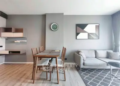 Modern living room with stylish decor and dining area, featuring a cozy sofa and elegant wooden dining set.