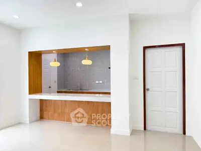 Modern kitchen with open layout and stylish pendant lights in a bright interior space.