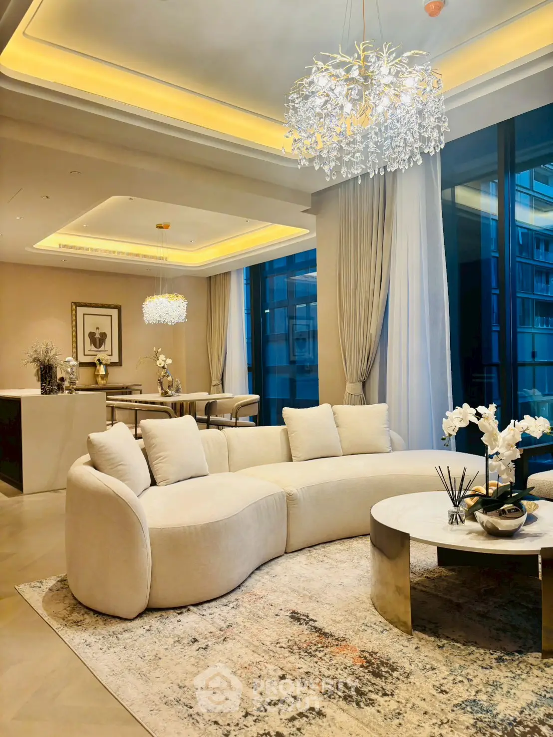 Luxurious living room with elegant chandelier and modern furniture in a high-end apartment.