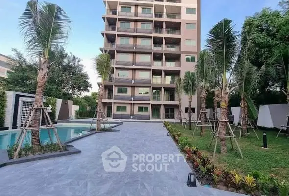 Modern apartment building with pool and landscaped garden, ideal for luxury living.