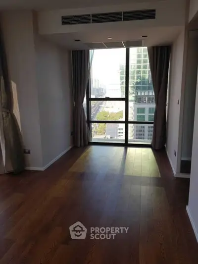 Spacious modern living room with large window and city view
