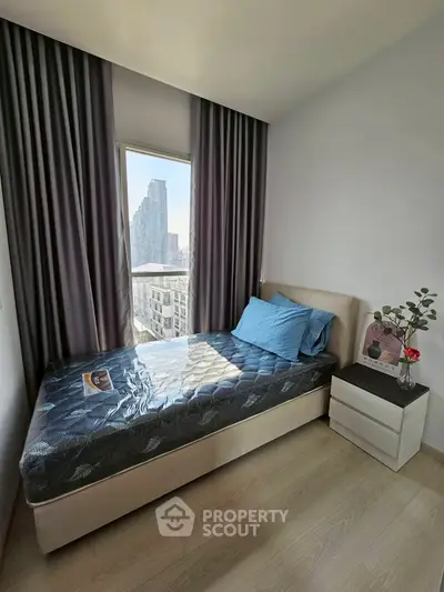 Cozy bedroom with city view, featuring a comfortable bed and modern decor, perfect for urban living.