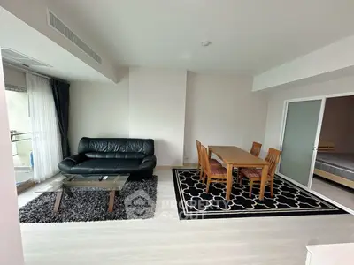 Spacious living room with modern furniture and dining area in a stylish apartment.
