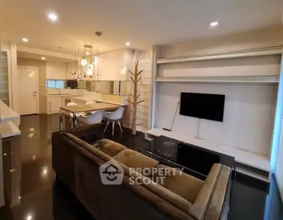 Modern open-plan living room with sleek kitchen and cozy seating area.