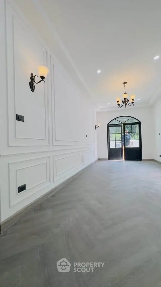 Elegant entrance with chandelier and classic wall paneling