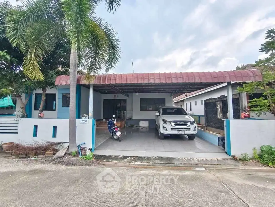 Charming single-story home with carport and lush greenery in a serene neighborhood.