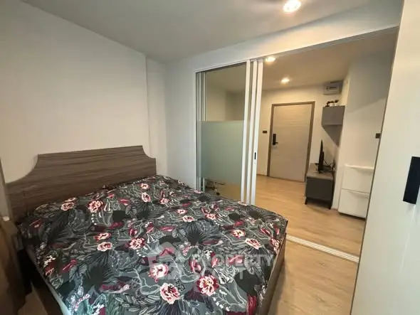 Cozy bedroom with floral bedding and sliding glass doors in modern apartment.