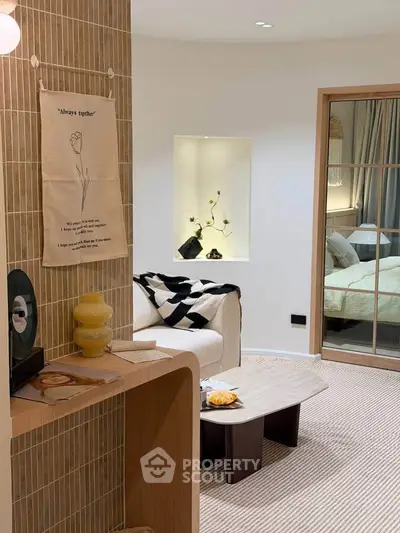Stylish modern living room with cozy decor and view into a chic bedroom