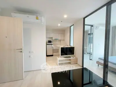 Modern open-plan living room with sleek kitchen and stylish decor in a contemporary apartment.