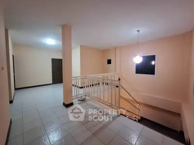 Spacious hallway with modern lighting and tiled flooring in a residential building.
