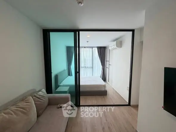 Modern apartment with glass partition separating living room and bedroom