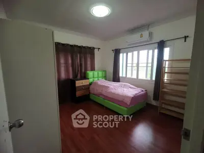 Spacious bedroom with modern furnishings and large window for natural light.