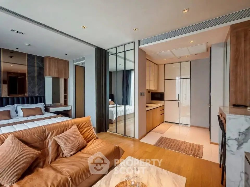 Luxurious open-plan living room with modern kitchen and cozy bedroom in a stylish apartment.