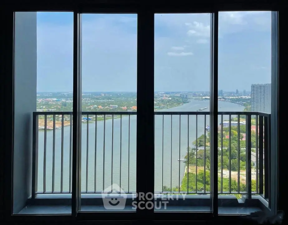 Stunning high-rise balcony view overlooking a serene river and cityscape, perfect for urban living.