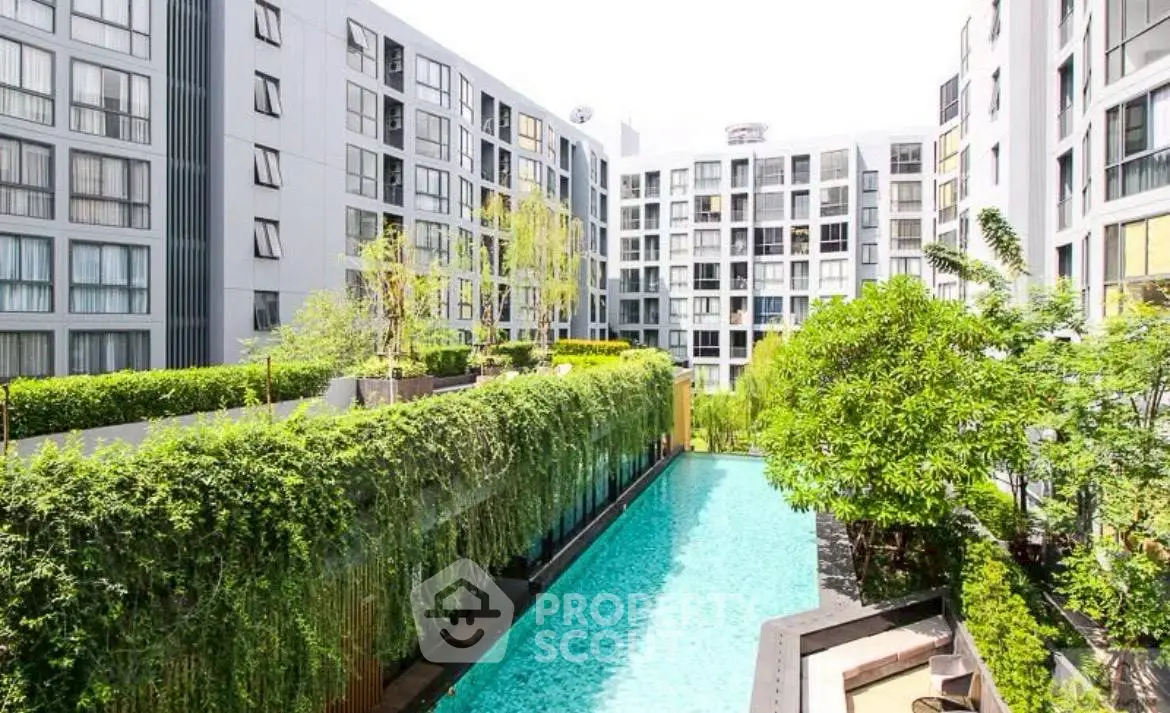 Modern apartment complex with lush greenery and inviting swimming pool