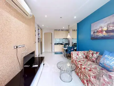 Charming living room with vibrant decor and open kitchen layout in modern apartment.