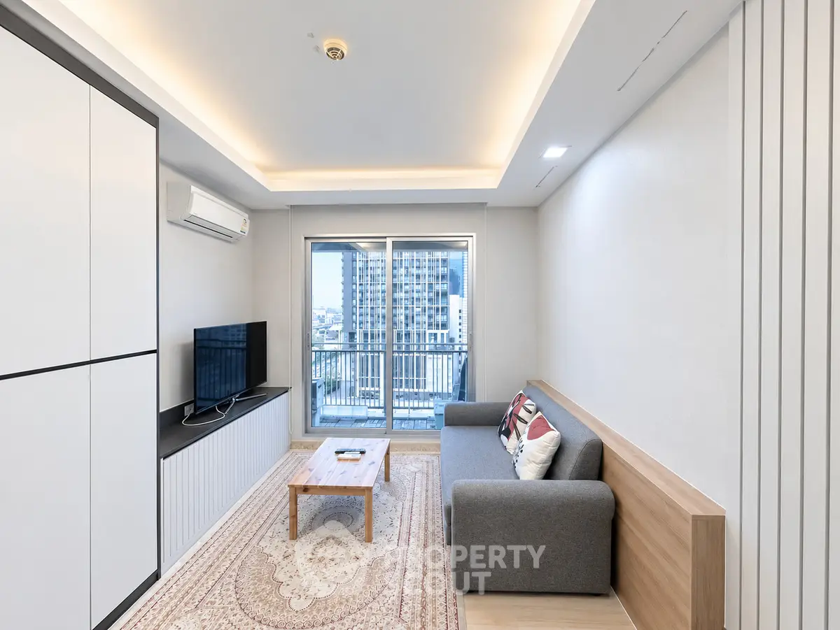Modern living room with balcony view, featuring sleek furniture and ambient lighting.