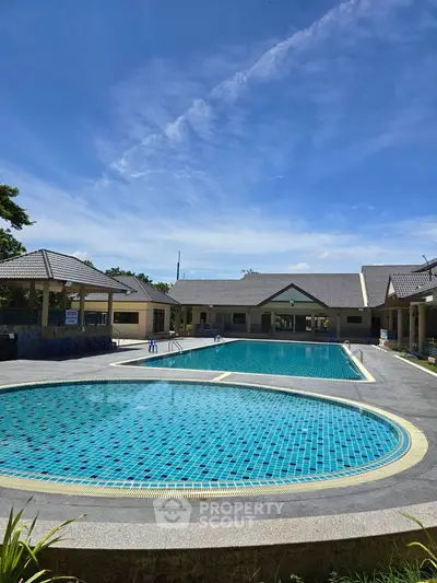 Luxurious residential pool area with clear blue skies and modern amenities.