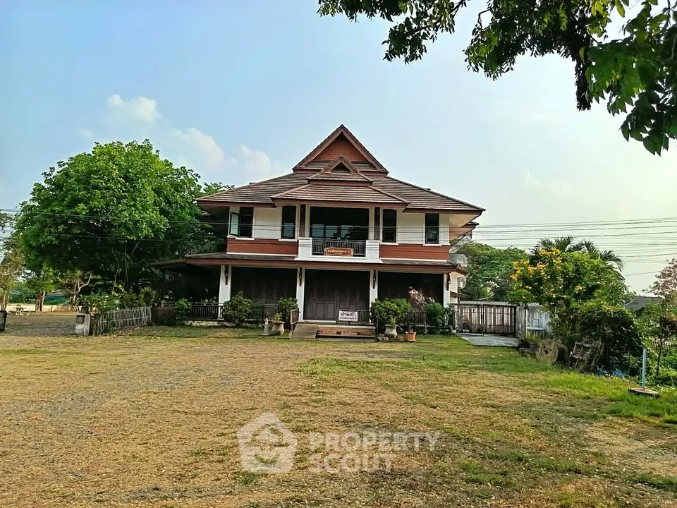Charming traditional house with spacious front yard and lush greenery, perfect for serene living.
