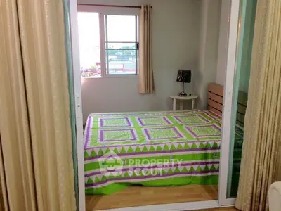 Cozy bedroom with vibrant bedding and natural light from window