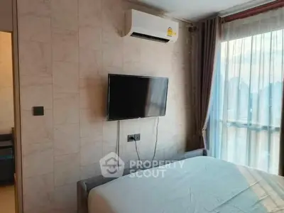 Modern bedroom with wall-mounted TV and air conditioning, featuring large window with curtains.