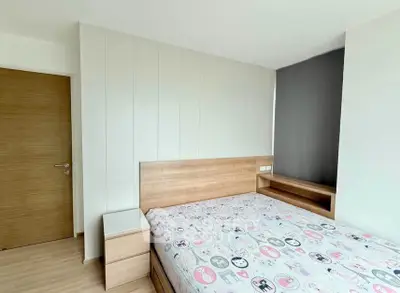 Modern bedroom with wooden furniture and stylish decor in a bright apartment.