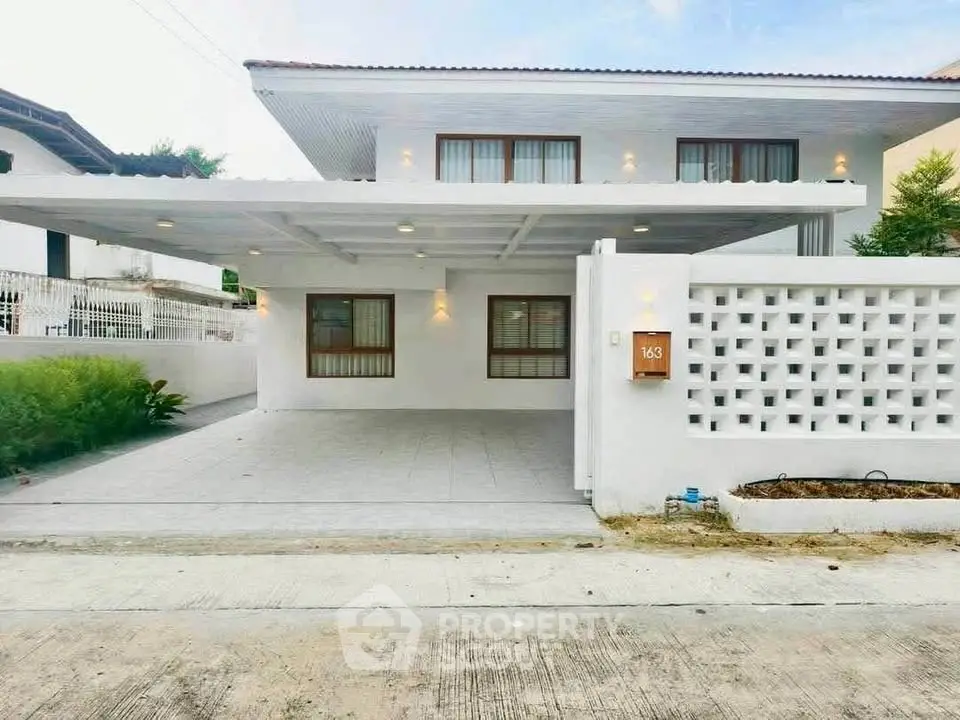 Modern two-story house with white facade and spacious driveway in a serene neighborhood.