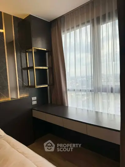 Modern bedroom with large window and elegant built-in desk offering stunning city views.
