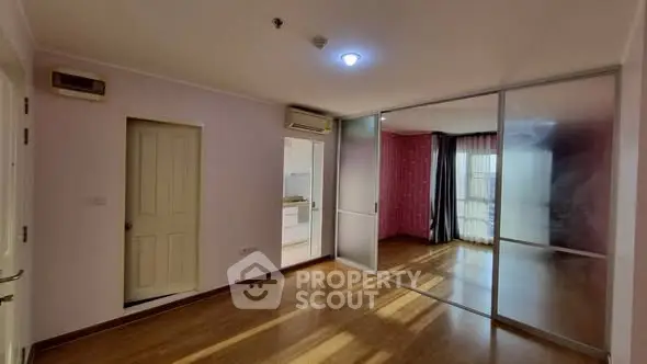 Spacious apartment with sliding glass doors and wooden flooring, ideal for modern living.