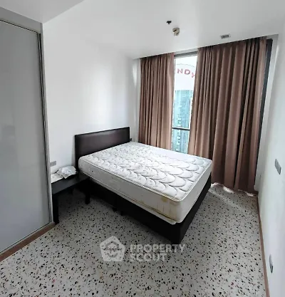 Modern bedroom with large window and city view, featuring a comfortable bed and stylish decor.