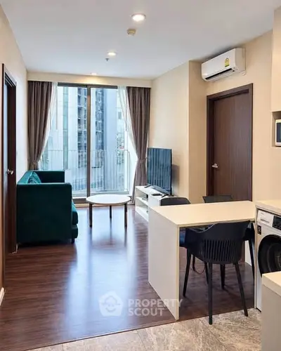 Modern living room with stylish furniture and large window view in urban apartment.