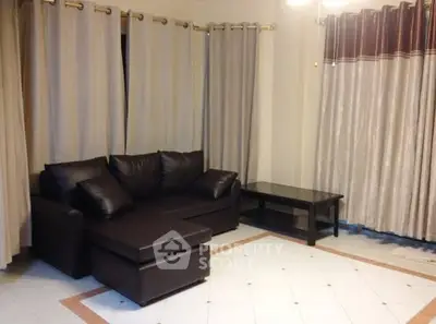 Spacious living room with elegant curtains and modern leather sofa