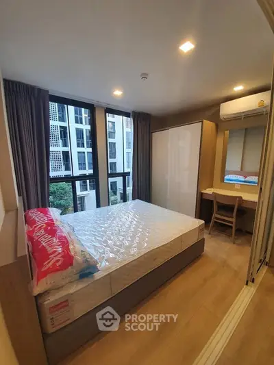 Modern bedroom with large windows and stylish furniture in a high-rise apartment.