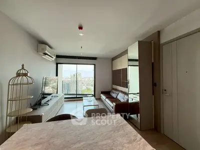 Modern living room with city view, featuring sleek furniture and large windows for natural light.