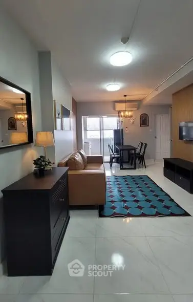 Modern living room with stylish decor and dining area, featuring a cozy sofa and elegant lighting.