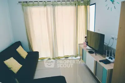 Cozy living room with modern TV setup and comfortable seating.