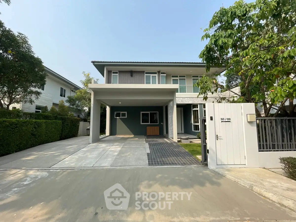 Modern two-story house with spacious driveway and lush greenery