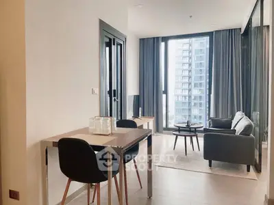 Modern living room with large windows and stylish furniture in high-rise apartment.