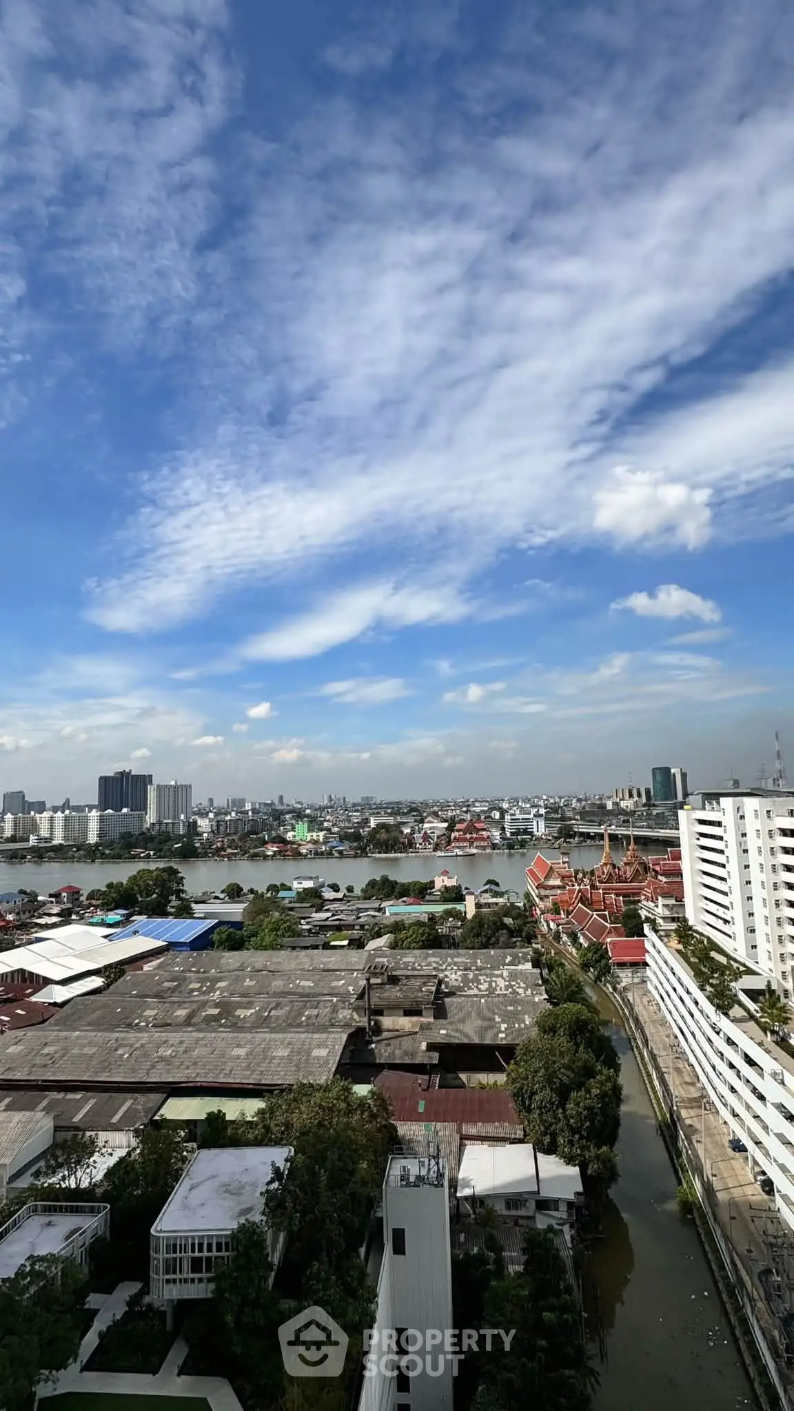 Stunning cityscape view from high-rise building with clear blue sky and river in the background.