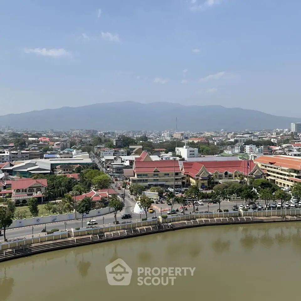 Stunning cityscape view with mountains and water feature, ideal for urban living.