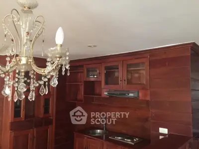 Luxurious wooden kitchen with elegant chandelier and modern appliances