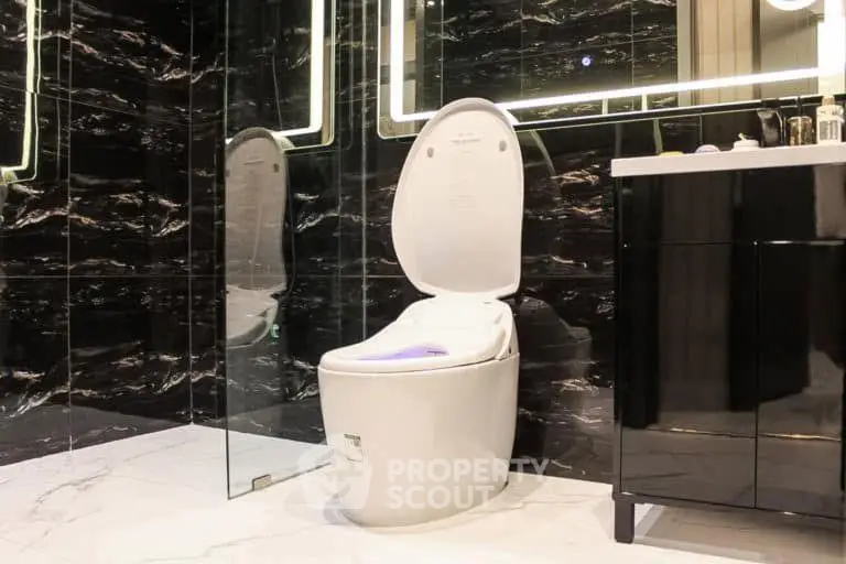 Luxurious modern bathroom with sleek black marble walls and high-tech toilet