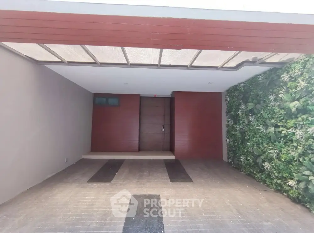 Modern entrance with sleek wooden door and vertical garden wall
