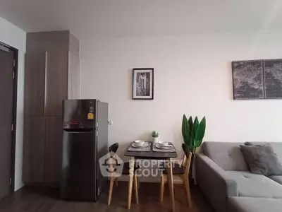 Modern living room with sleek furniture and dining area, featuring a stylish fridge and elegant decor.