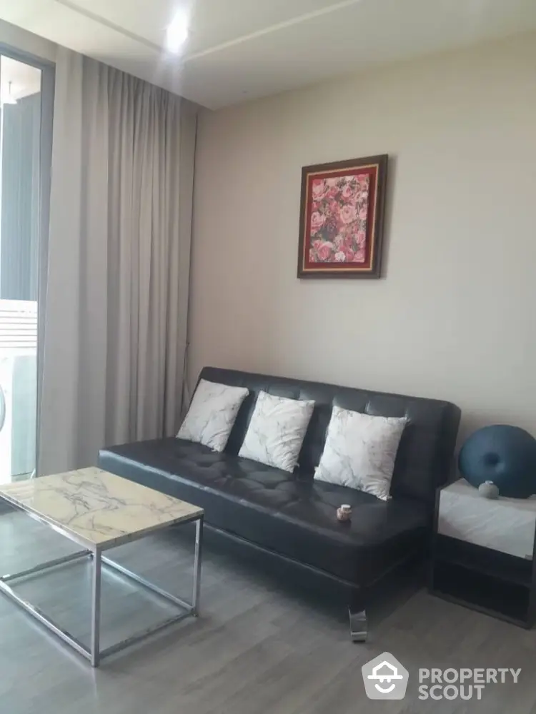 Modern living room with sleek black sofa and marble coffee table, perfect for stylish urban living.