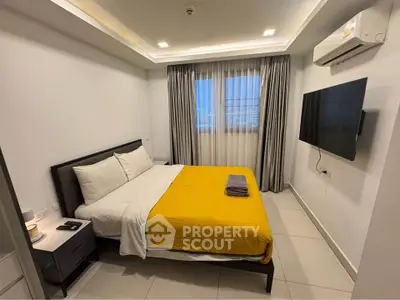 Modern bedroom with sleek design, featuring a large bed, wall-mounted TV, and ambient lighting.